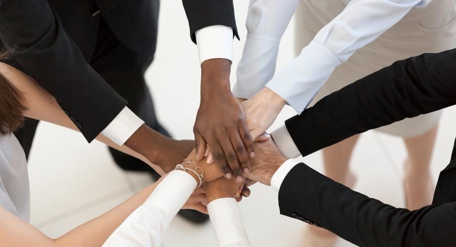 Business people putting their hands together in a circle
