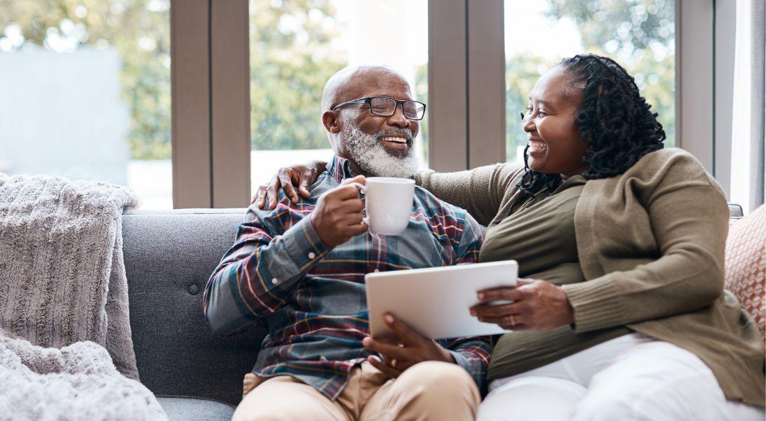 Husband and wife drinking coffee on couch