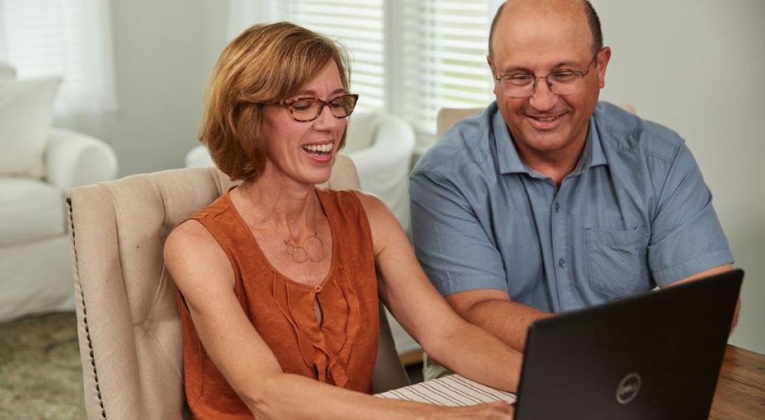 Couple sitting at the table on a laptop