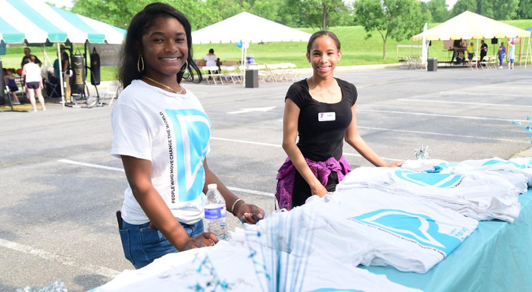 Two volunteers handing out t-shirts at the Moving Day walk