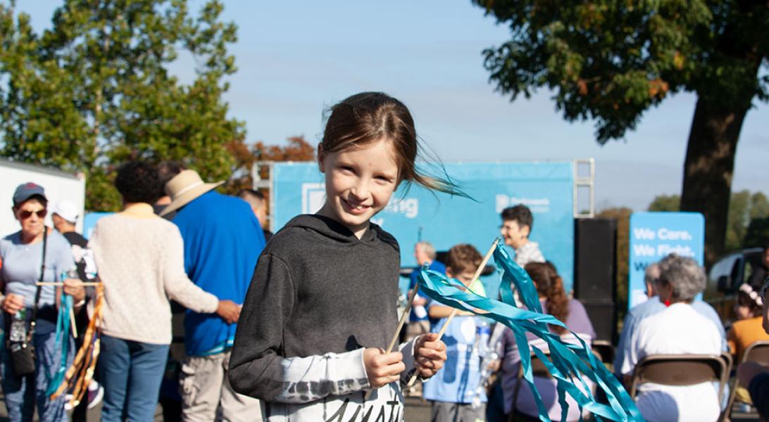 Child waving ribbons at the Moving Day walk for Parkinson's