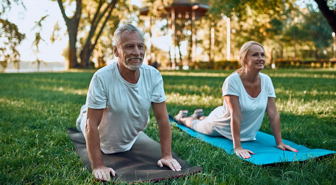 Two people doing yoga outside