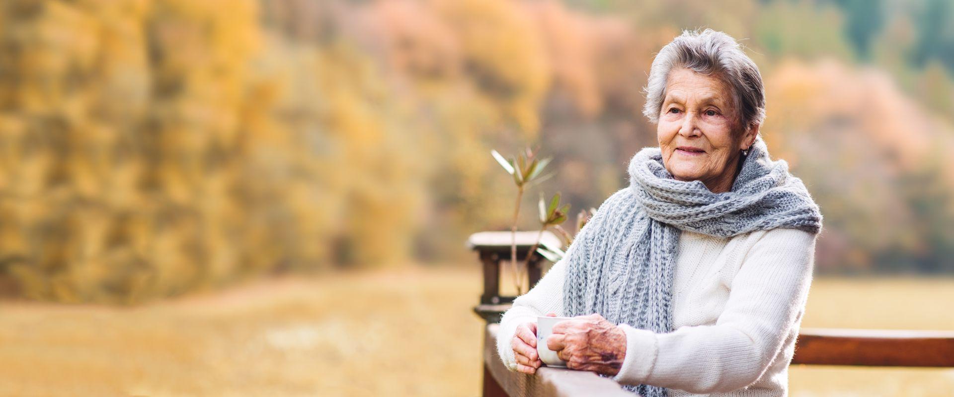 Woman standing drinking coffee on her deck