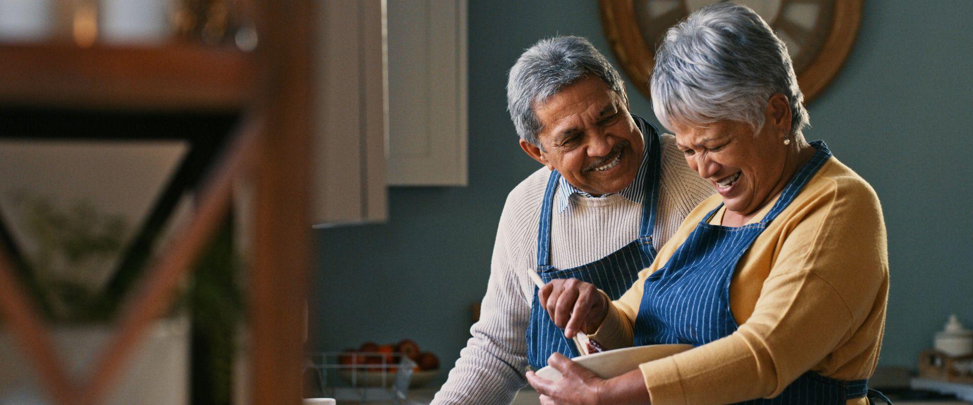 Husband and wife cooking in kitchen
