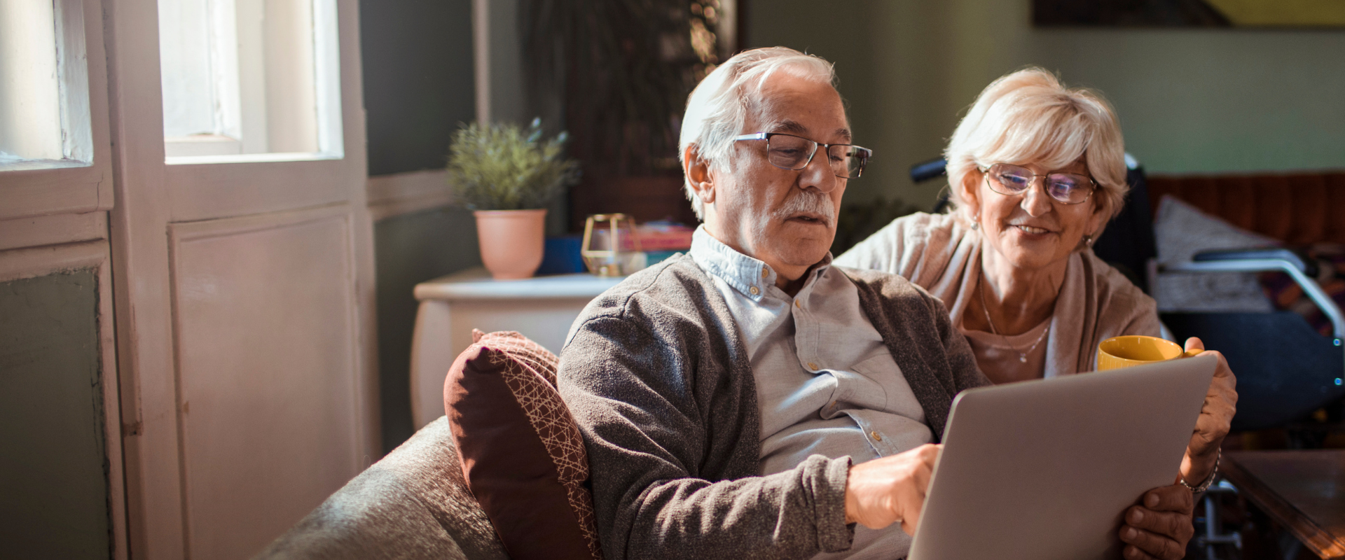 Couple sitting on couch looking at laptop