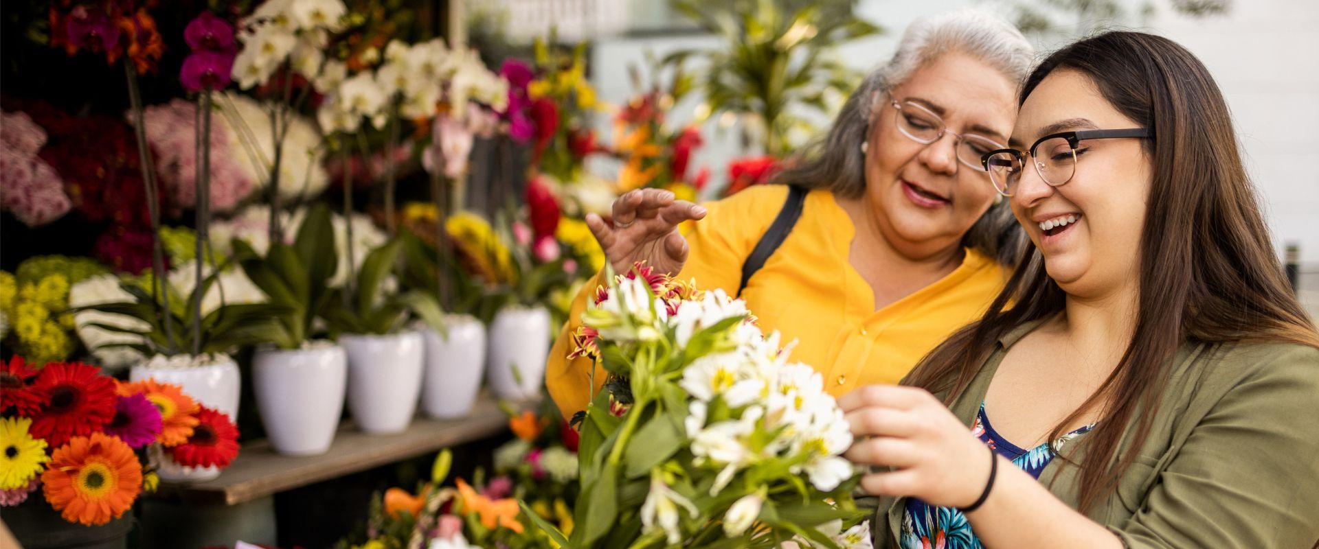 Mother and daughter looking at flowers at market