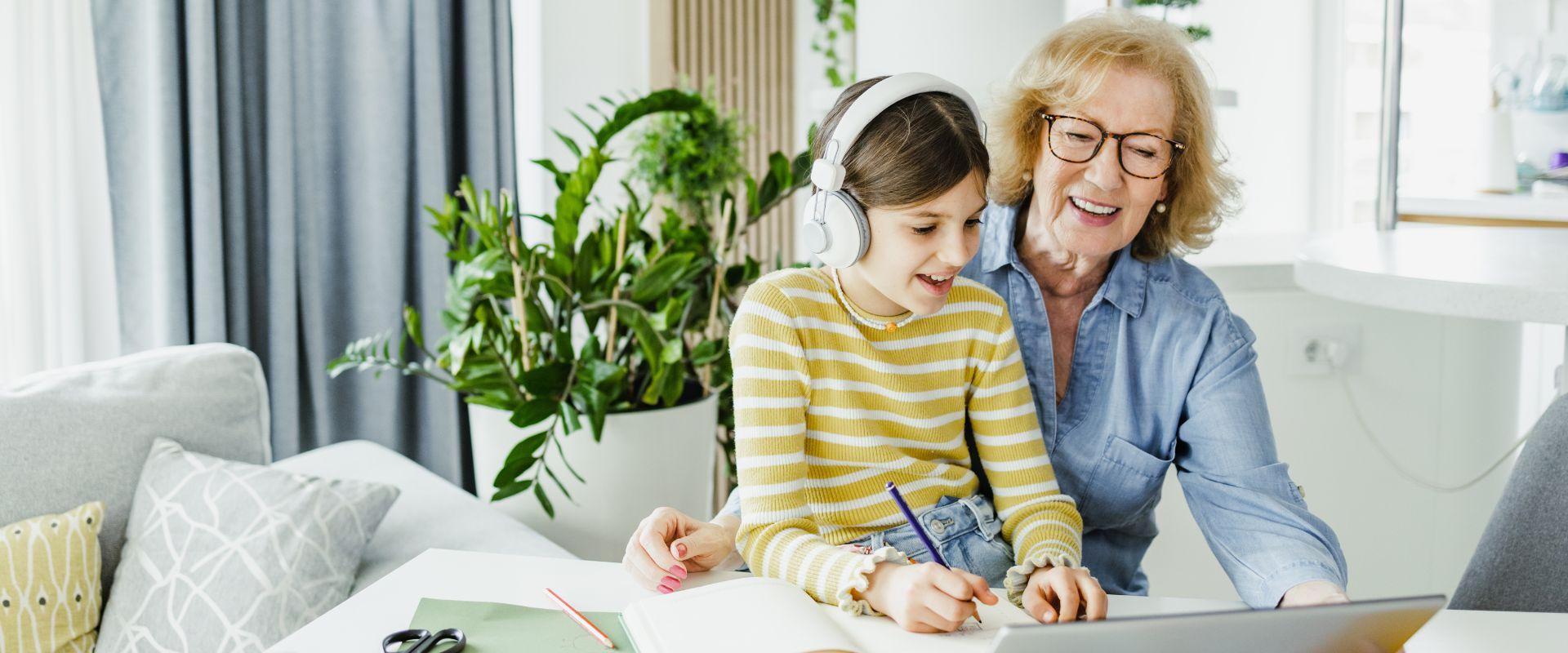 Grandma looking at laptop with granddaughter