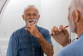 Older man brushing his teeth