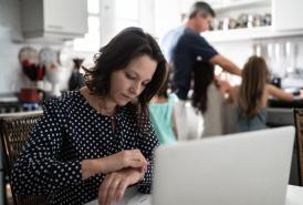 Woman working from home with family in the background