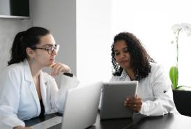 Two female researchers looking at a laptop and tablet
