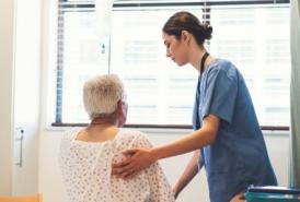 Nurse assisting patient out of hospital bed