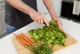 Man cutting lettuce and carrots 