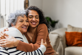 An older and younger women hugging