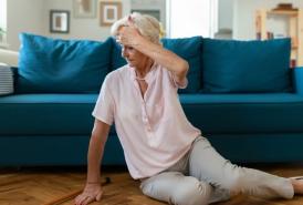 Lady got dizzy and fell on her living room floor and holding her forehead