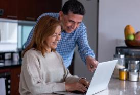 pareja mirando una computadora portátil