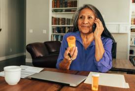 Woman talking on the phone, holding a pill bottle