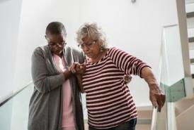 Lady helping a woman down the stairs