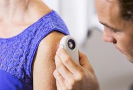 Doctor checking a patients skin with dermatoscope