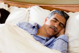 Husband and wife sleeping in bed