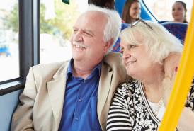 Couple sitting on a bus smiling out the window
