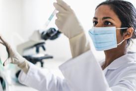Researcher testing a vial in lab