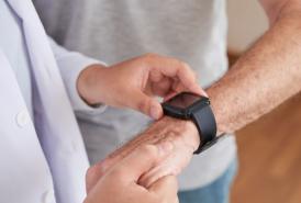 Doctor looking at a patient's movement-tracking device on his wrist