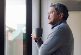 Man looking thoughtfully out the window