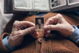 Older person holding a photograph of a young man