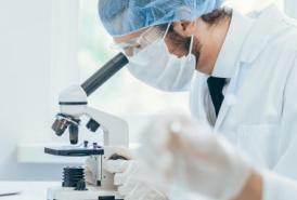 Lab tech looking through microscope