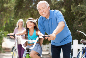 grandparent helping grandchild ride bike