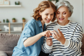 grandma and granddaughter using an iphone