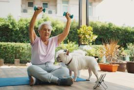 Woman working out outside with her dog.