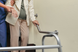 Nurse assisting someone with a walker