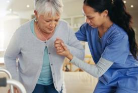 Nurse helping senior woman stand