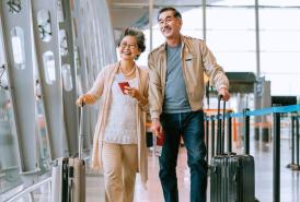 A couple walking through the airport with their bags