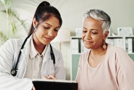 Doctor and senior woman looking at tablet together