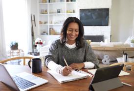 Woman writing notes at her desk