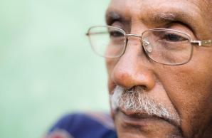 Close-up of man wearing glasses staring into distance with serious expression