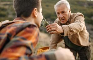 Man holding flower up to son's nose