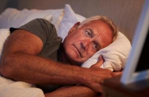 Man laying in bed with eyes open