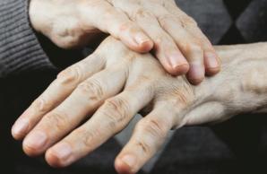 Close up of person's hands, one hand placed on top of the other