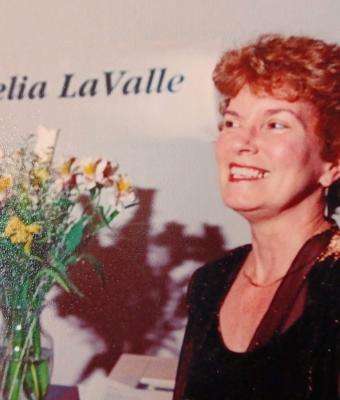 Cecilia smiling brightly next to a bouquet of flowers at what appears to be a formal event.