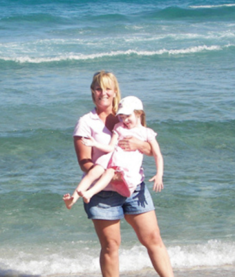 Kelly Maurer holding daughter at beach