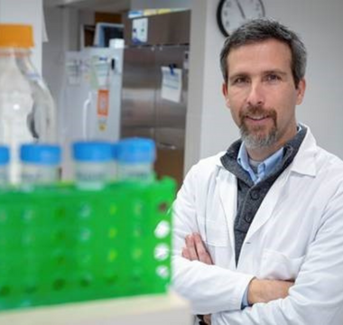 Male scientist posing in lab by vials