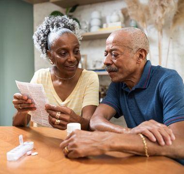 Couple sitting at the table reviewing medication paperwork