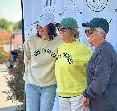 Three women at a golf tournament