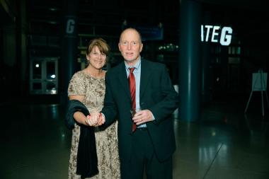 Joe Staub holding hands with his wife at a formal event.