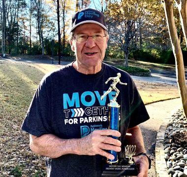 Jim McLaughlin holding a Moving Day walk trophy