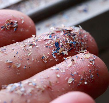 Small pieces of plastic waste on fingers