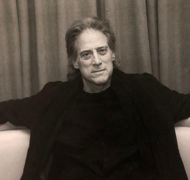 Richard Lewis sitting on couch